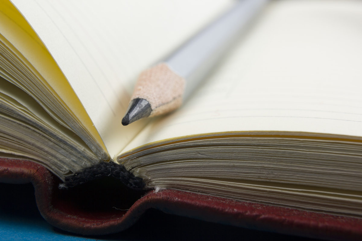 Photo of Notepad and pencil closeup