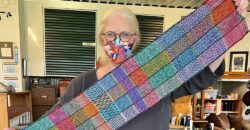 Patti holding a long narrow weaving sample of patterns